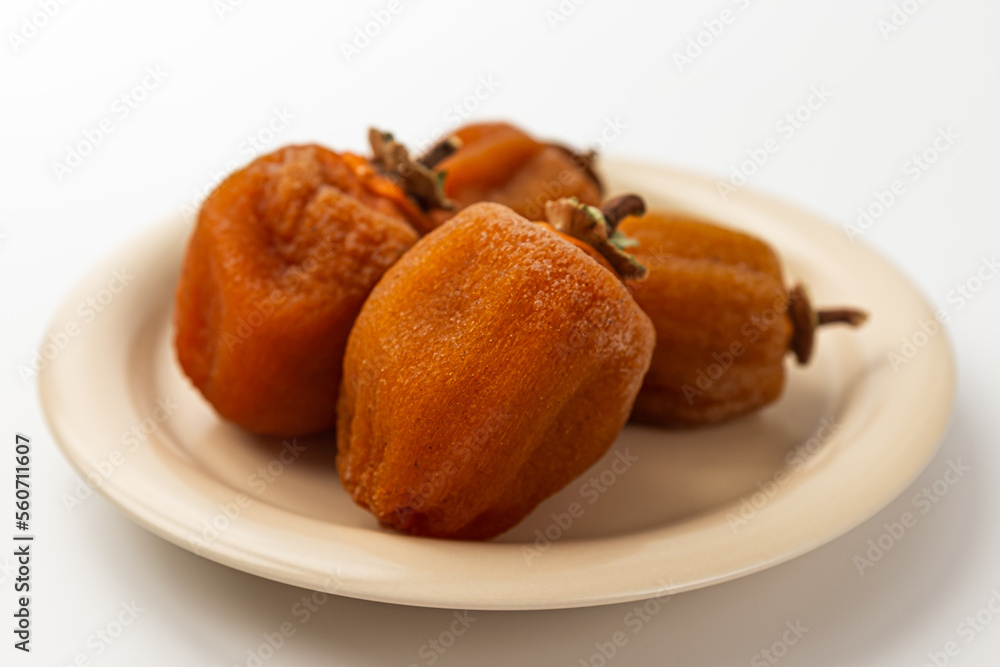 Half dried persimmon on a white background Half dried persimmon on a white background