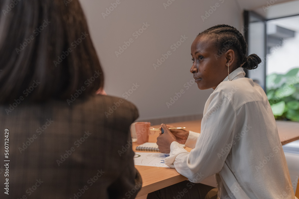 © Milles Studio/Stocksy - Black manager looking away and listening to colleague © Milles Studio/Stocksy - Black manager looking away and listening to colleague