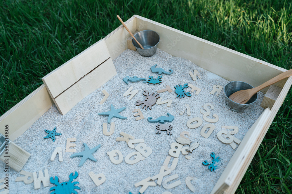 Wooden thematic toys in sensory box in park