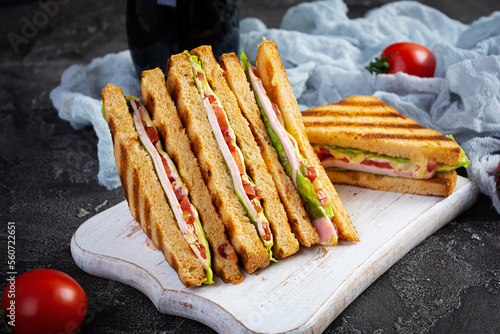 Club sandwich with ham, tomato, green and cheese. Grilled panini