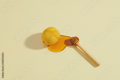 Honey and lemons on a ligth yellow background closeup photo