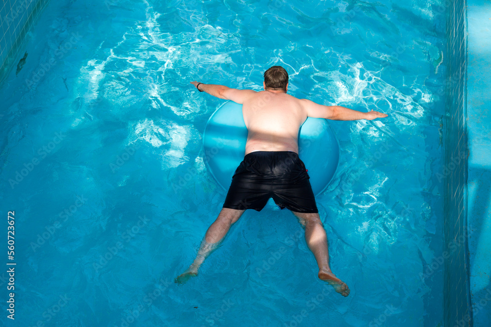 A man floats on an inflatable circle, top view.
