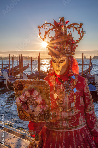 Colorful carnival mask against gondolas at a traditional festival in Venice, Italy