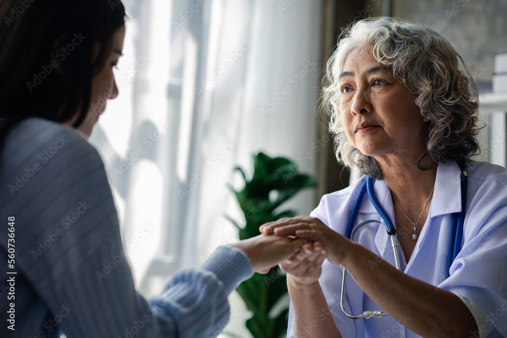 Elderly doctor and patient sitting in examination room, doctor giving advice on diagnosis of the patient and finding the right way to treat the disease. The concept of treatment by a specialist doctor Elderly doctor and patient sitting in examination room, doctor giving advice on diagnosis of the patient and finding the right way to treat the disease. The concept of treatment by a specialist doctor