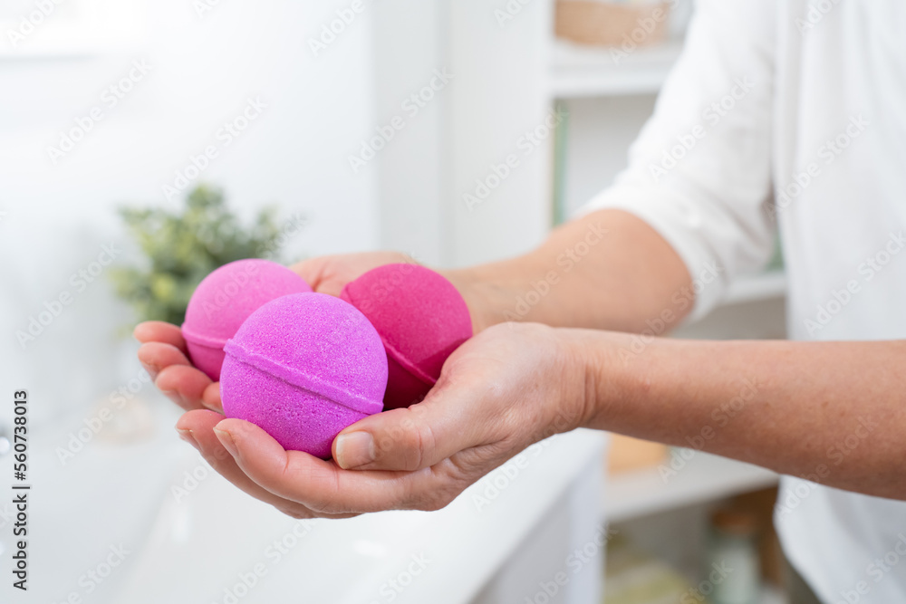 Closeup of a woman's hands with pink salt and soap balls in the bathroom for skin and body care. High quality photo Closeup of a woman's hands with pink salt and soap balls in the bathroom for skin and body care. High quality photo