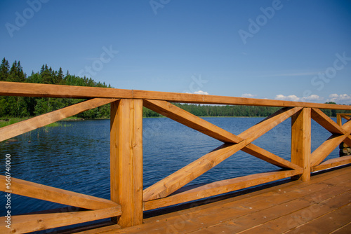 A new wooden jetty on the calm waters of a lake on a sunny summer day. Clear blue skies and calm weather © Aritel