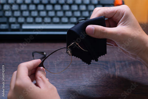 Wiping eyeglasses with a micro cleaning cloth to prevent scratching and keep eyeglasses clean, cleaning concept.