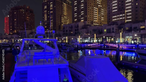 Yacht luxury expensive boat in the club in Doha Qatar Garmin navigation system in the sea water tower hotel buildings in the background at night in pearl lulu mall qanat quartier island katara lusail