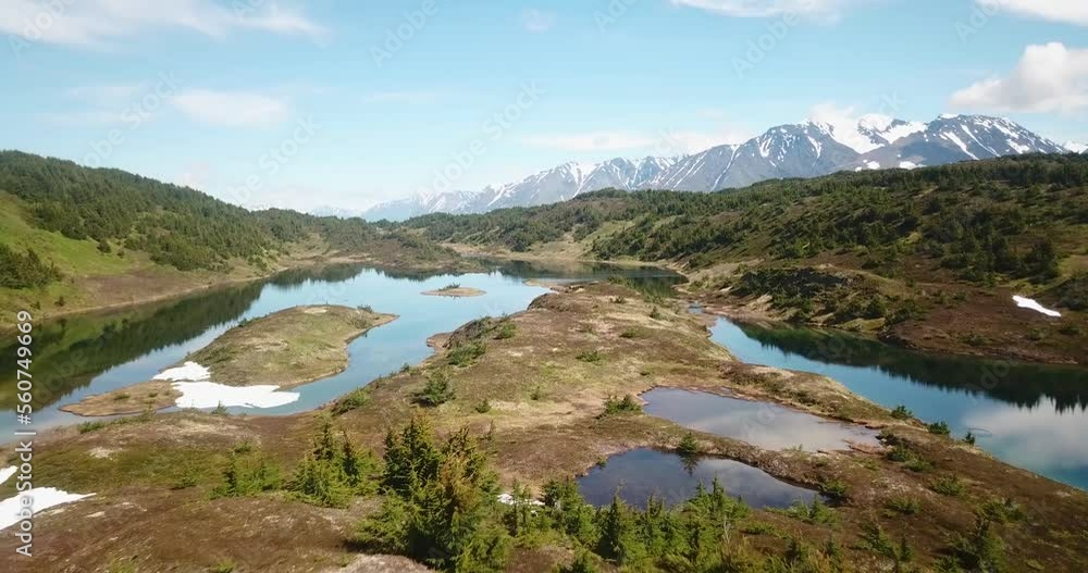 Drone shot of a man walking towards isolated lakes in the Alaskan backcountry. Drone shot of a man walking towards isolated lakes in the Alaskan backcountry.