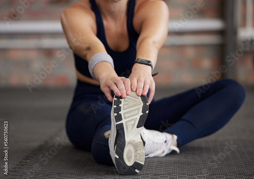 Woman, legs and stretching in fitness gym for workout, training and exercise muscle pain, tension release and body healthcare wellness. Sports athlete, personal trainer and coach in warm up routine