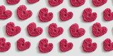 Crocheted amigurumi pink hearts on a white background. Valentine's pattern top view