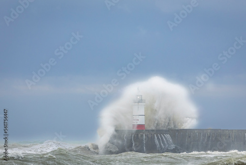 Crashing waves on a windy winters day at Newhaven lighthouse looking west from Seaford East Sussex south east England