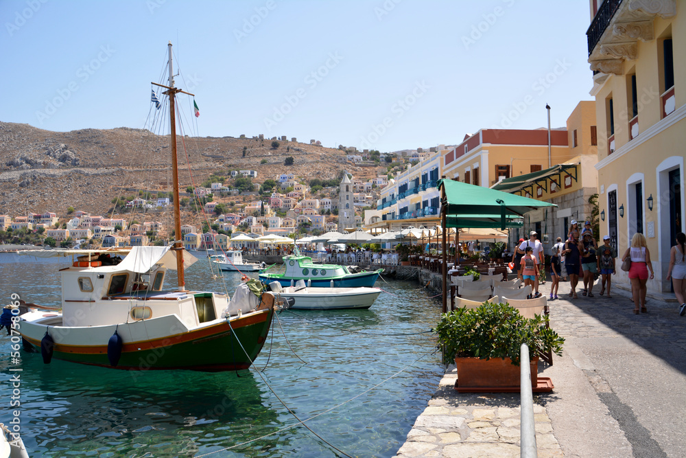 waterfront with boats and painted buildings and cafes of greek island Symi