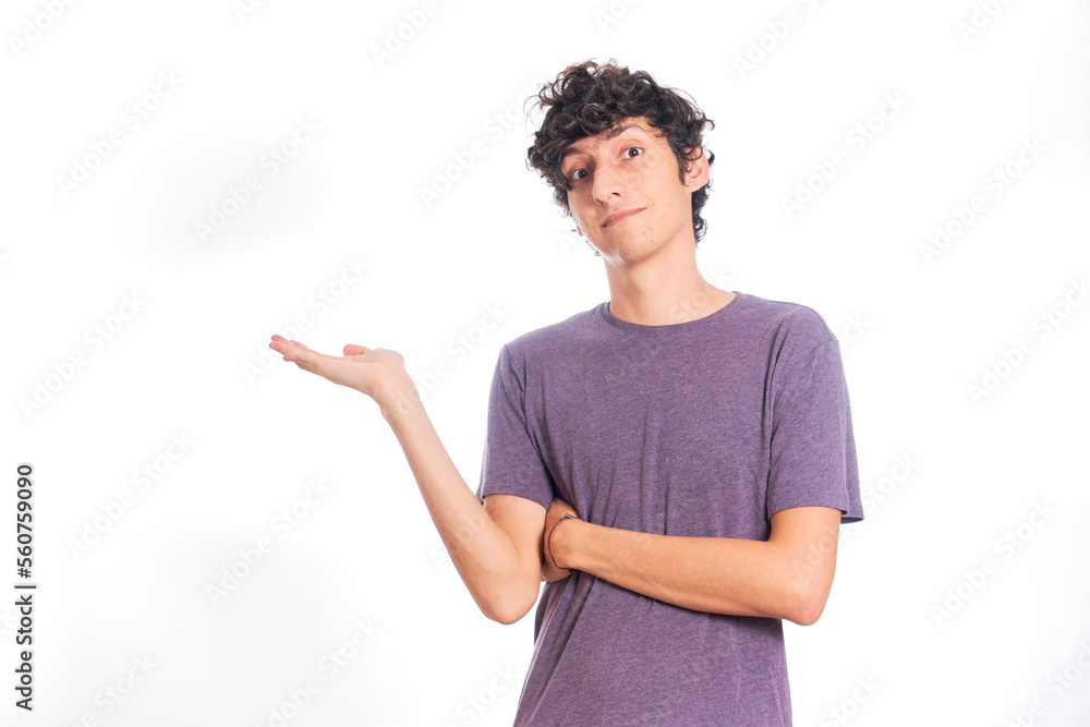 Young Hispanic man pointing copyspace. Isolated on white background. Young Hispanic man pointing copyspace. Isolated on white background.