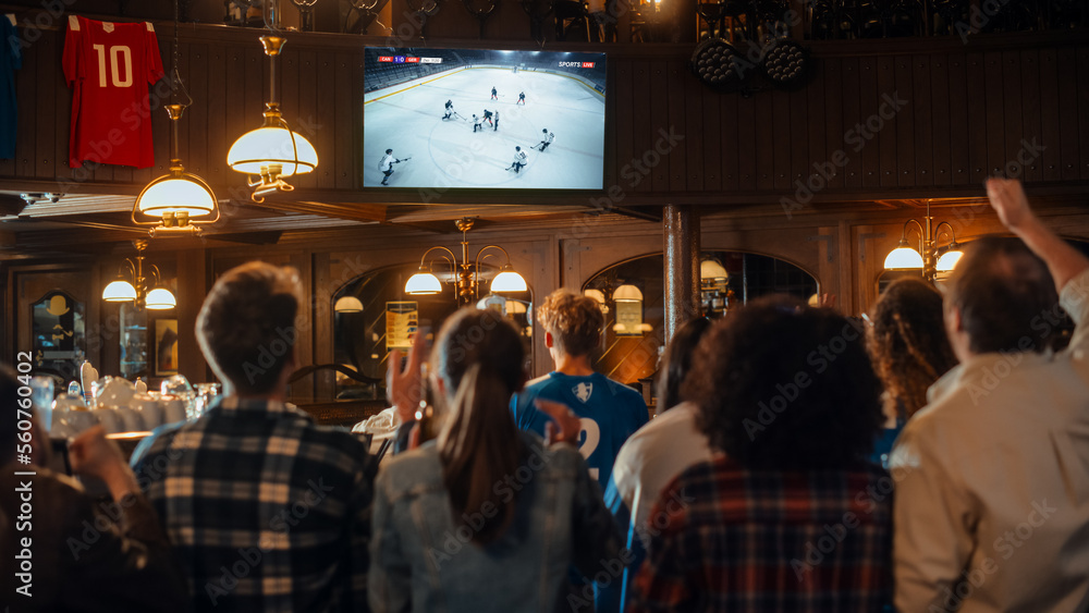 Group of Ice Hockey Fans Watching a Live Match Broadcast in a Sports Pub on TV. People Cheering, Supporting Their Team. Crowd Goes Ecstatic When Team Scores a Goal and Wins the Championship.