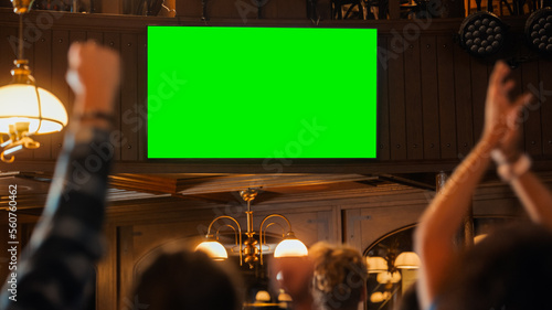 Canvas Print Group of Multicultural Friends Watching a Live Sports Match on TV with Green Screen Display in a Bar