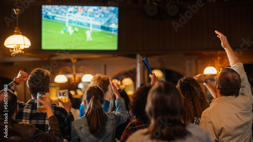 Soccer Club Members Cheering for Their Team, Playing in an International Cup Final. Supportive Fans Standing in a Bar, Cheering, Raising Hands and Shouting. Friends Celebrate Victory After the Goal. photo
