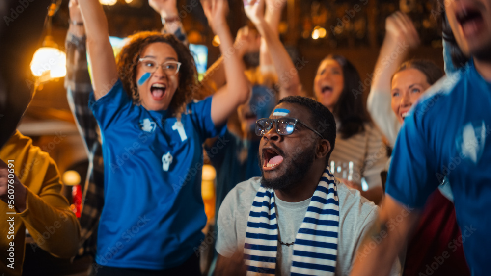 Group of Multiethnic Friends Watching a Live Soccer Match on TV in a Sports Bar. Fans with Painted Faces Cheering. Young People Celebrating When Team Scores a Goal and Wins the Football World Cup. Group of Multiethnic Friends Watching a Live Soccer Match on TV in a Sports Bar. Fans with Painted Faces Cheering. Young People Celebrating When Team Scores a Goal and Wins the Football World Cup.