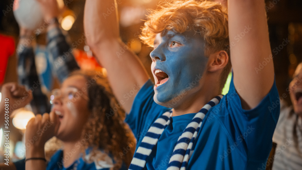 Diverse Group of Soccer Fans with Colored Faces Watching a Live Football Match in a Sports Bar. People Cheering for Their Team. Player Scores a Goal and Crowd Celebrate Winning the Championship. Diverse Group of Soccer Fans with Colored Faces Watching a Live Football Match in a Sports Bar. People Cheering for Their Team. Player Scores a Goal and Crowd Celebrate Winning the Championship.
