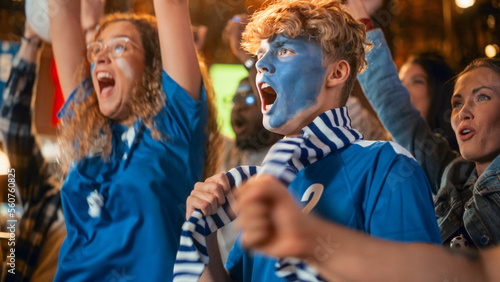 Diverse Group of Soccer Fans with Colored Faces Watching a Live Football Match in a Sports Bar. People Cheering for Their Team. Player Scores a Goal and Crowd Celebrate Winning the Championship.