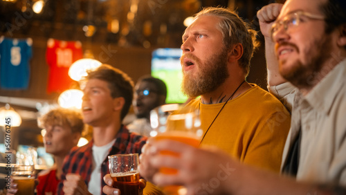 Group of Good Friends Enjoying Their Time in a Sports Pub. Three Men Cheering for Their Favorite Soccer Team. Young People Celebrating and Toasting Beer Glasses When Players Score a Goal and Win.
