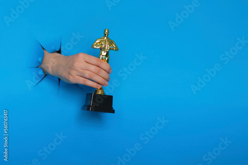 Fototapeta Hollywood Golden Oscar Academy award statue in hand isolated on white background