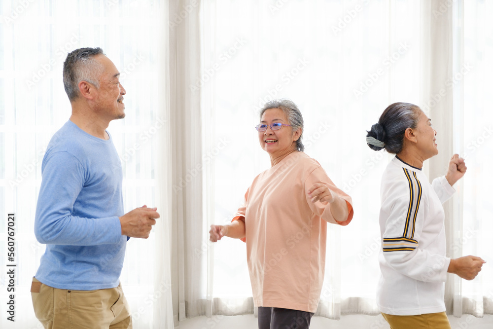 Active Asian senior group mix with man and woman exercise by dancing together with relaxing, smiling and laughing. Indoor activity for mature seniors and retirement people. Focus on senior woman. Active Asian senior group mix with man and woman exercise by dancing together with relaxing, smiling and laughing. Indoor activity for mature seniors and retirement people. Focus on senior woman.