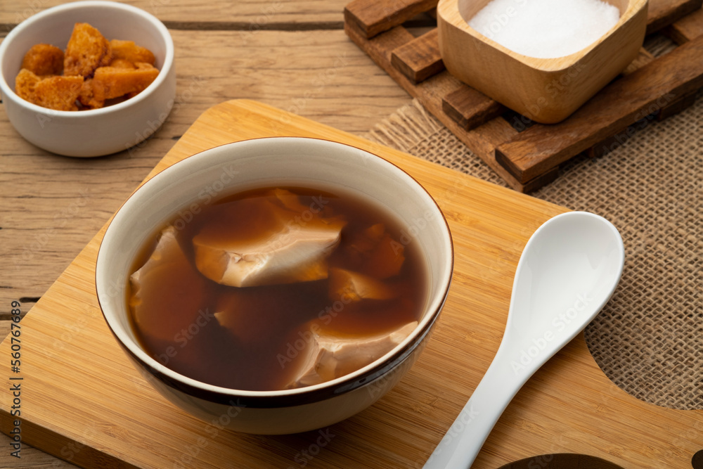 Boiled Soft tofu pudding (soy bean curd) in ginger juice soup in a bowl Boiled Soft tofu pudding (soy bean curd) in ginger juice soup in a bowl