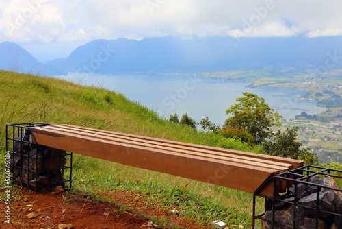 a unique wooden bench on the hill of Lawang Indonesia with views of Lake Maninjau below