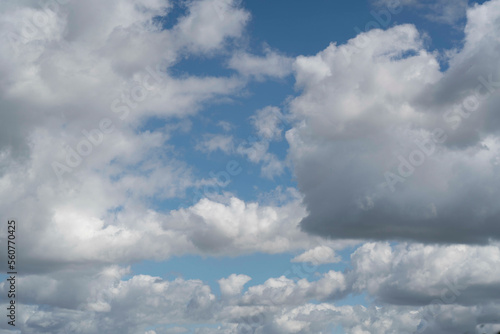 Cumulus clouds against a bright, blue summer sky.