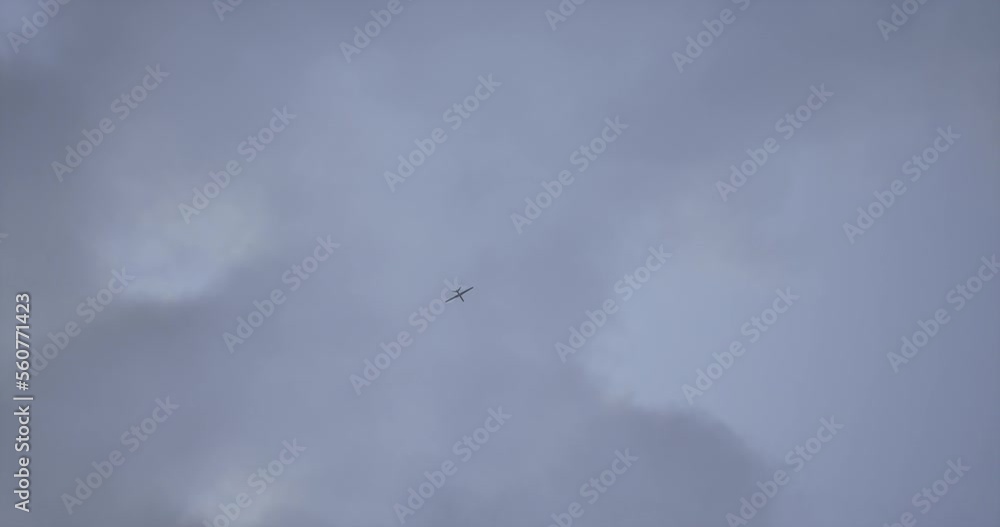HANDHELD Witness record of a UAV military drone flying against the sky during war conflict HANDHELD Witness record of a UAV military drone flying against the sky during war conflict