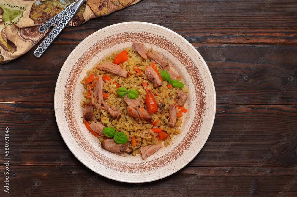 asian dish, uzbek pilaf with meat on a wooden table, flat lay asian dish, uzbek pilaf with meat on a wooden table, flat lay