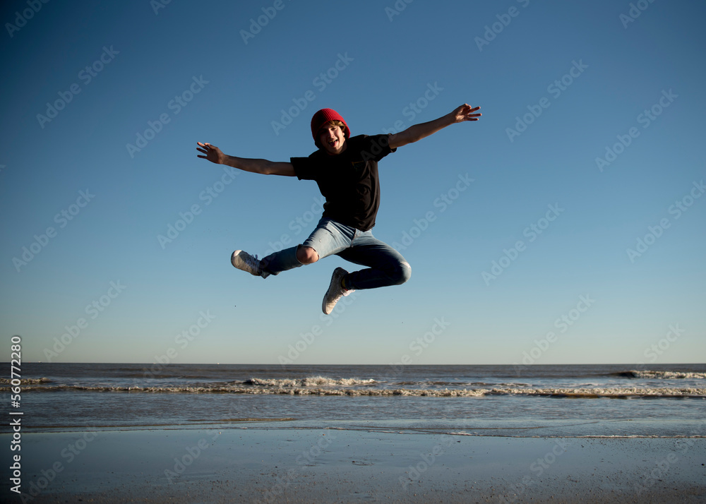Happy teenage boy jumping on the beaches of Galveston, Texas. Happy teenage boy jumping on the beaches of Galveston, Texas.