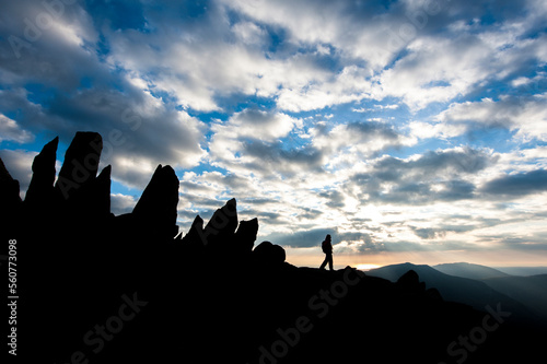 A hillwalker admiring a mountaintop sunset. photo