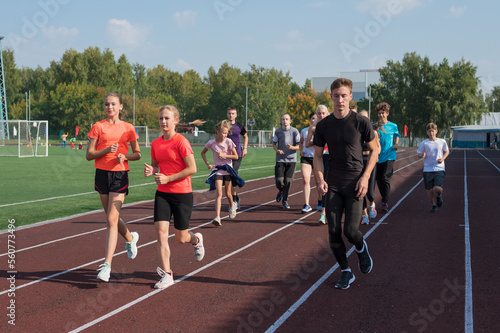 Group of young athletes training at the stadium. School gym trainings or athletics © olinchuk
