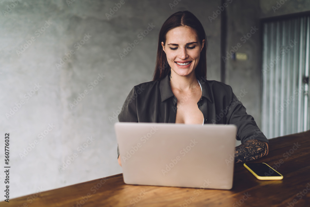 Smiling woman using laptop at table Smiling woman using laptop at table