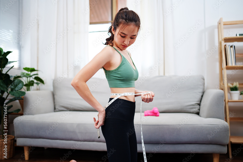 Close up thin woman measuring her hip with tape measure. Close up thin woman measuring her hip with tape measure.