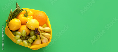 Fototapeta Naklejka Na Ścianę i Meble -  Shopping bag with fresh fruits and vegetables on green background with space for text