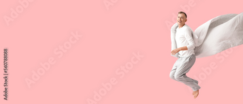 Jumping young man in pajama...
