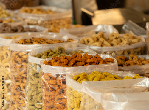 Transparent bags of cookies in the street market in Bari, Italy. Colored cookies like red, yellow, green with pistachio, red berries and other condiments.