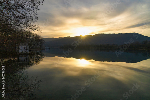 The last rays of sun hide in the mountains that surround the lake of Banyoles, Catalonia, Spain