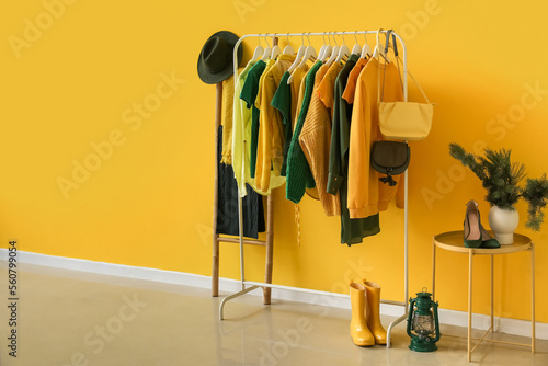 Rack with stylish female clothes and accessories in interior of room