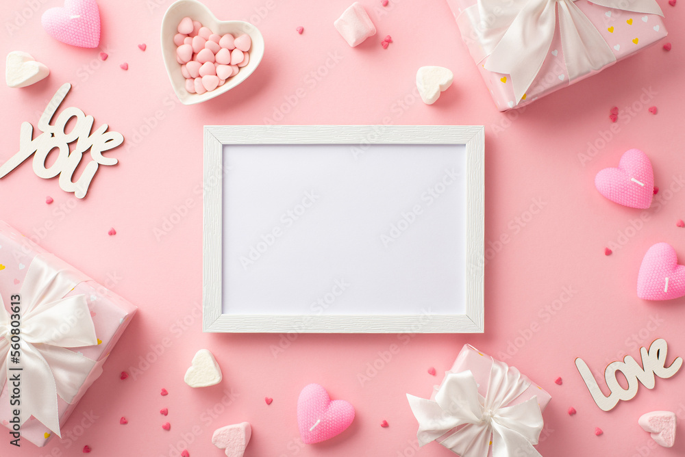 Valentine's Day concept. Top view photo of white photo frame gift boxes heart shaped saucer with sprinkles candles marshmallow and inscriptions love on isolated pastel pink background with blank space Valentine's Day concept. Top view photo of white photo frame gift boxes heart shaped saucer with sprinkles candles marshmallow and inscriptions love on isolated pastel pink background with blank space