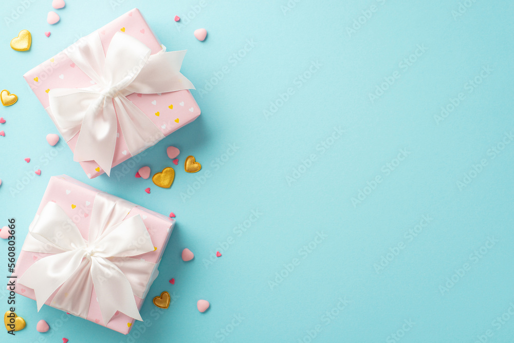 Valentine's Day concept. Top view photo of pastel pink gift boxes with white ribbon bows golden hearts and sprinkles on isolated light blue background with copyspace Valentine's Day concept. Top view photo of pastel pink gift boxes with white ribbon bows golden hearts and sprinkles on isolated light blue background with copyspace