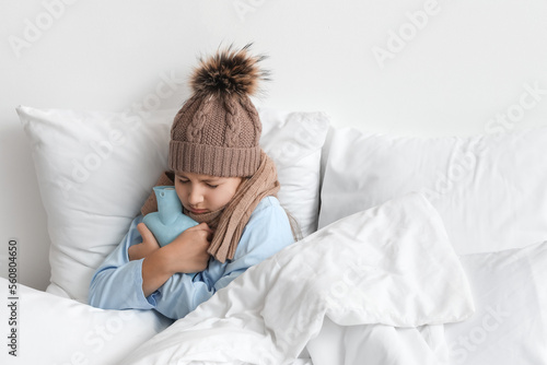 Fototapeta Ill girl with hot water bottle lying in bed at home