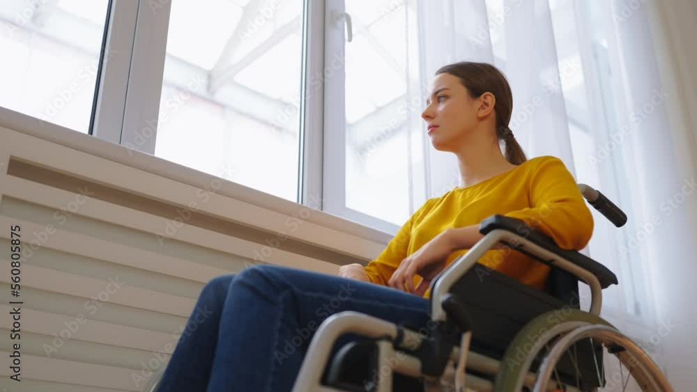 Portrait of upset woman with physical disability feeling lonely near the window Portrait of upset woman with physical disability feeling lonely near the window