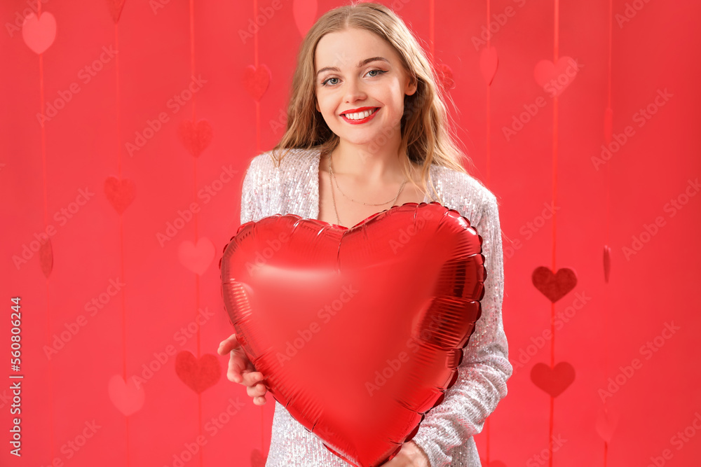 Beautiful young woman with heart-shaped balloon on red background. Valentine's Day celebration Beautiful young woman with heart-shaped balloon on red background. Valentine's Day celebration