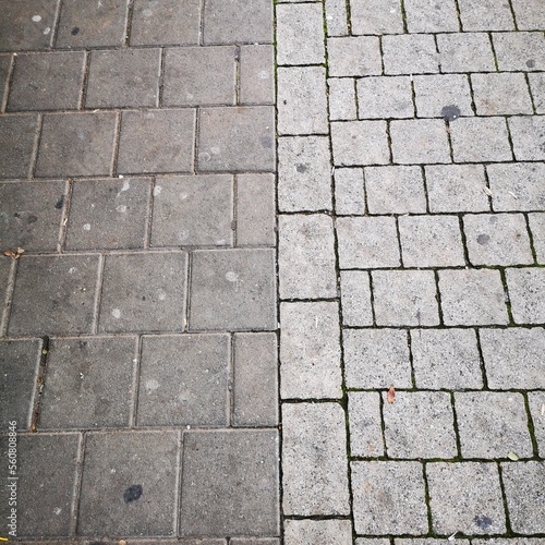 The sidewalk is lined with square gray tiles.