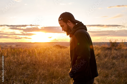 Male standing in countryside nature relaxing, having rest after training alone . caucasian guy in black sportive clothes during sunset. man lead healthy active lifestyle, stand thinking, motivated © alfa27