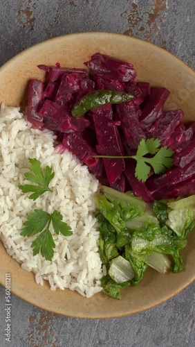 Top view of beetroot curry with sona masoori rice and stir-fried lettuce. Table spin. Vertical video. photo